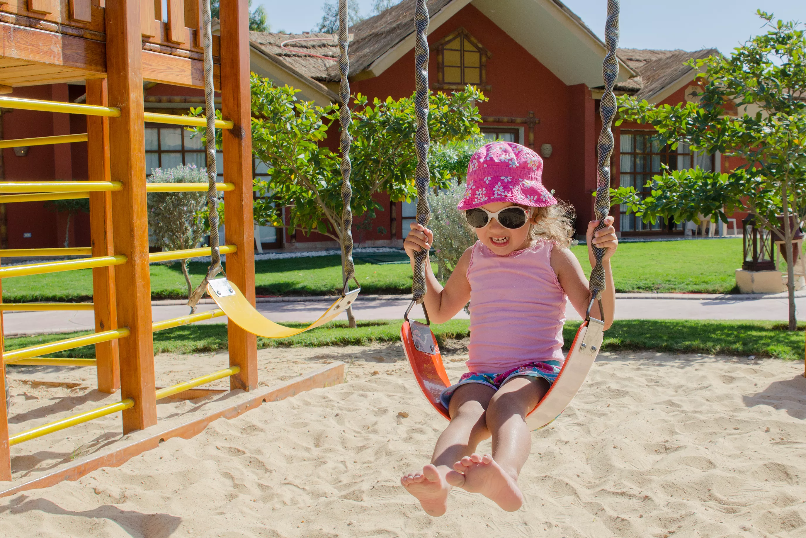 Little girl on swing in playground Little girl on swing in playground